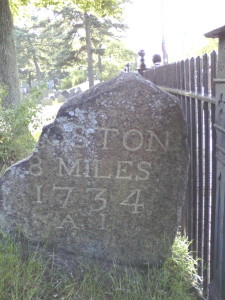  Milestone indicating 8 miles to Boston, 1734, bearing the initials AI which stands for Alexander Ireland, a surveyor. Removed to a place inside the fence of the First Parish Cemetery, Cambridge, in 1892, it is located near the grave of the man whose initials it bears.